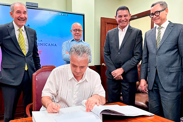 El Dr. Santos Gracia firmando el libro de visitas del MESCYT.